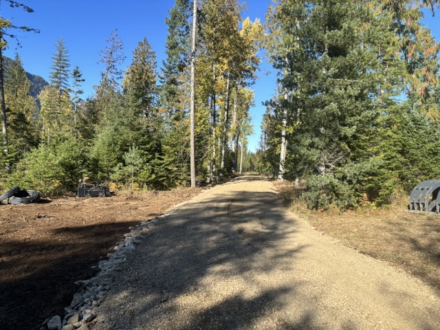 Finished gravel road with rock-lined drainage edge — Clark Fork, ID